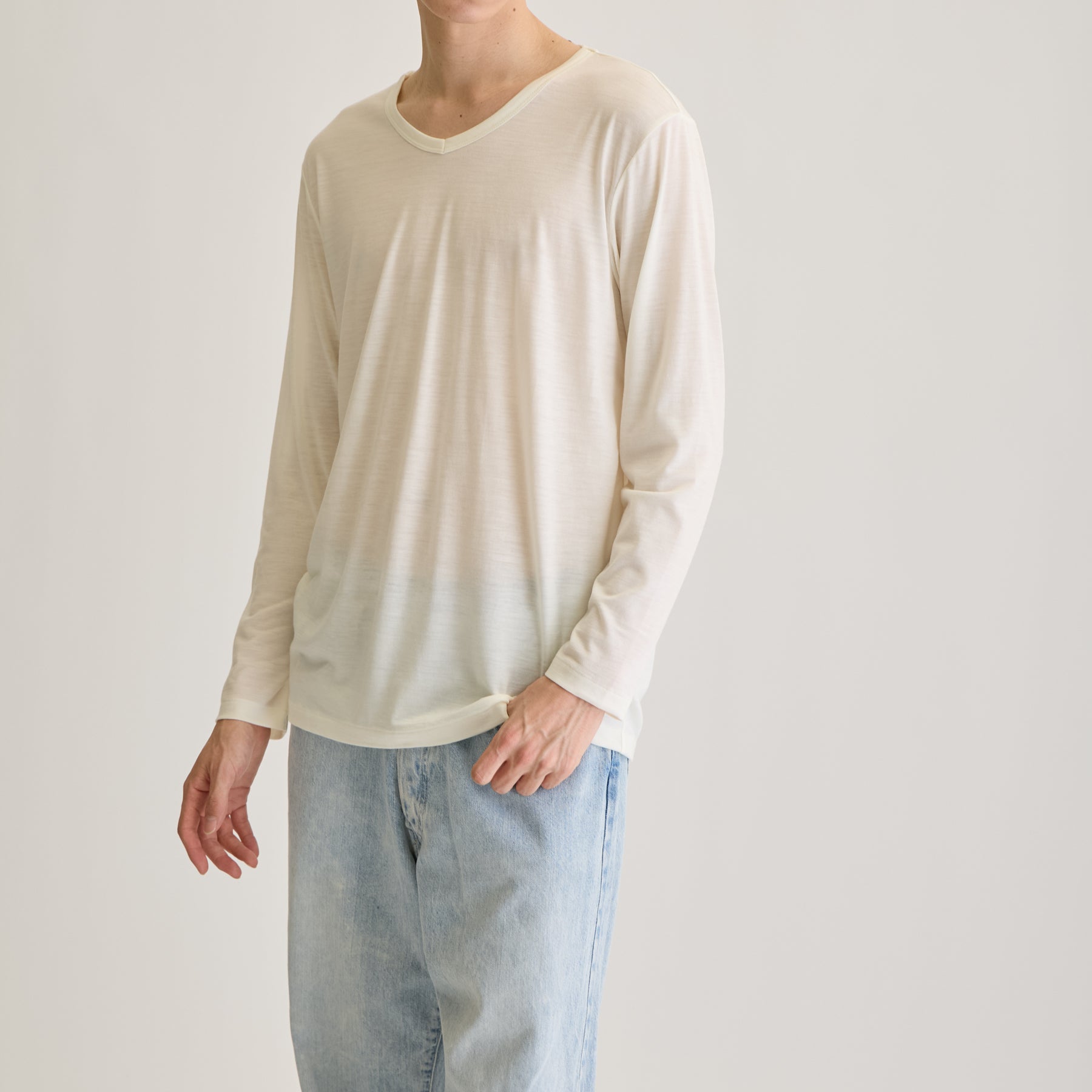 MEN'S メリノウール100%天竺 Vネック長袖Tシャツ, ホワイトのモデル着用画像(斜め前)