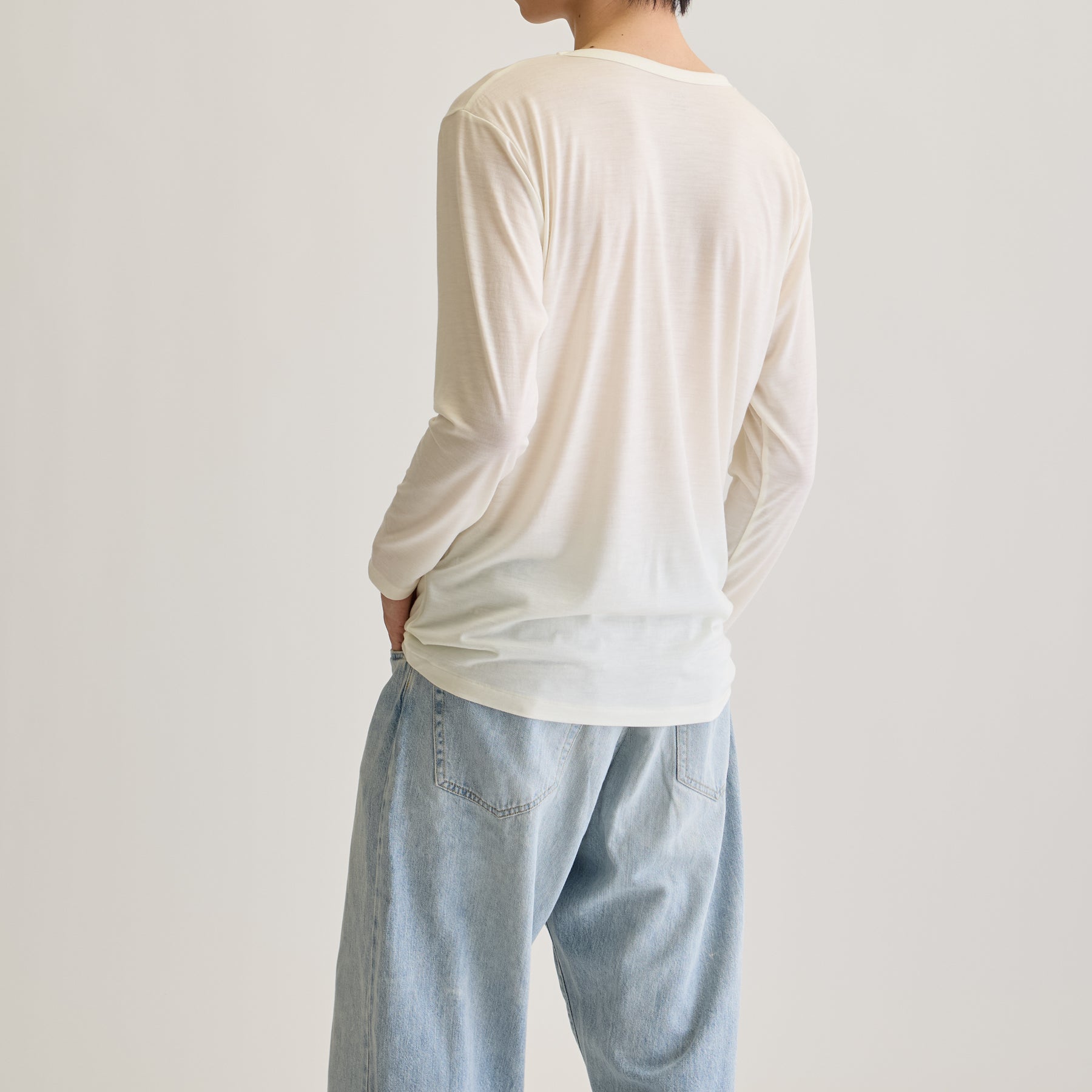 MEN'S メリノウール100%天竺 Vネック長袖Tシャツ, ホワイトのモデル着用画像(斜め後)