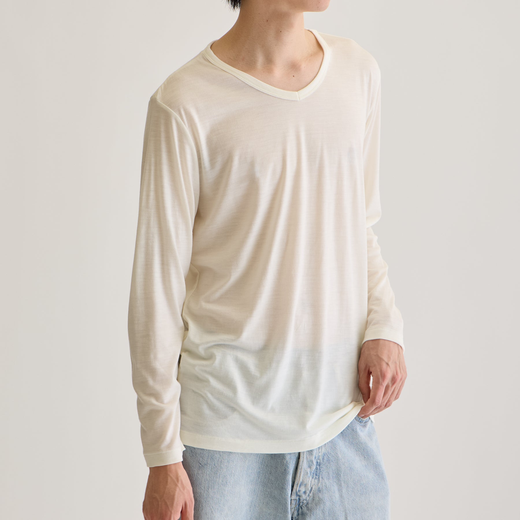 MEN'S メリノウール100%天竺 Vネック長袖Tシャツ, ホワイトのモデル着用画像（斜め前）