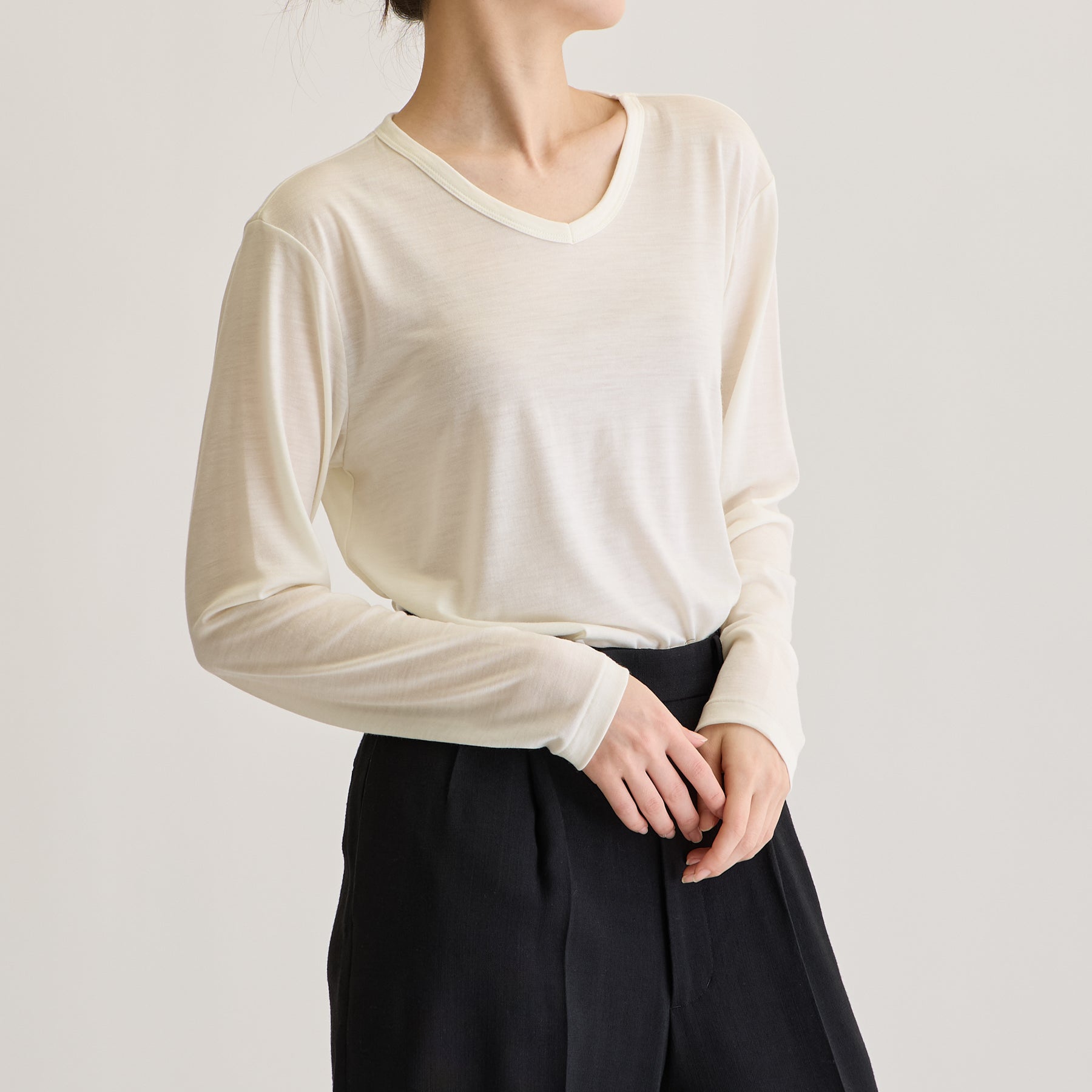 MEN'S メリノウール100%天竺 Vネック長袖Tシャツ, ホワイトのモデル着用画像（女性・斜め前）